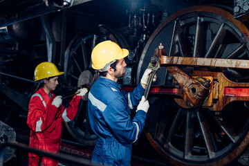 Team of engineer railway wearing safety uniform and helmet under checking under train ,wheels and control system for safety travel passenger. Maintenance cycle concept.