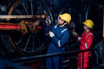 Fototapeta premium Team of engineer railway wearing safety uniform and helmet under checking under train ,wheels and control system for safety travel passenger. Maintenance cycle concept.