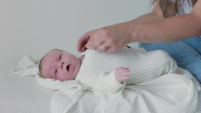 baby boy looks around while mom changes his outfit