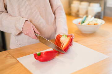 Girl cutting red bell pepper