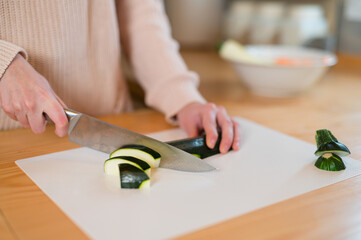 Girl hands cutting green zucchini into slices for a healthy meal
