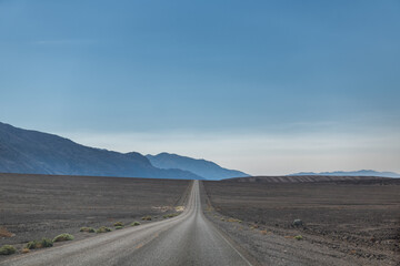 A long road stretches across a desert landscape