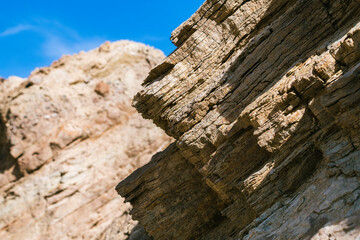 A rocky cliff with a blue sky in the background
