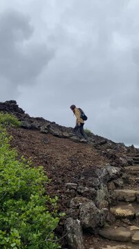 male hiker climbs up to volcano Eldborg crater in Iceland