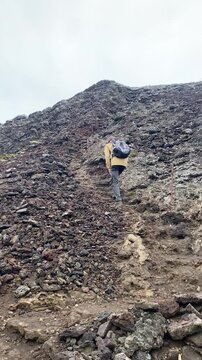 male hiker climbs up to volcano Eldborg crater in Iceland