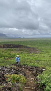 female hiker climbs up to volcano Eldborg crater in Iceland