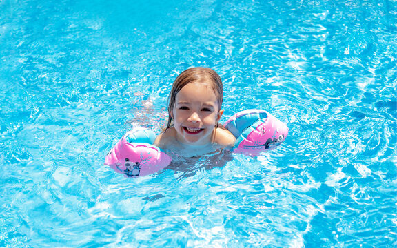 girl learning to swim in the pool
