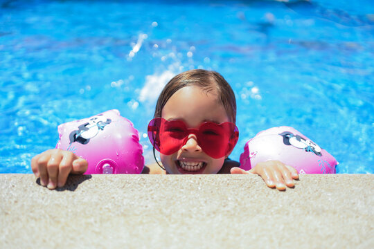 girl with sunglasses happy in the pool