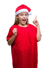 Young beautiful girl wearing christmas hat over isolated background pointing finger up with successful idea. Exited and happy. Number one.