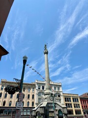 Monument and historic buildings in Troy, NY against clear blue sky © Cavan