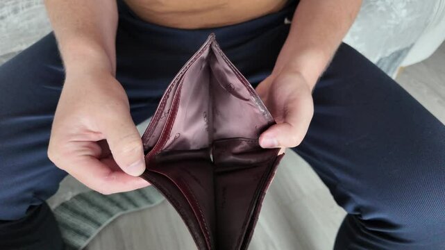 Wallet without money in the hands of a man