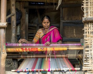 Indian woman working cloth on handloom in village settingries.Traditional Indian weaver crafting on handloom.