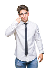 Young business man wearing glasses over isolated background Pointing with hand finger to face and nose, smiling cheerful