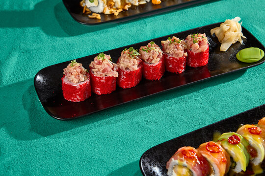 Crab Rolls with Tobiko on Black Plate – Vibrant Sushi Presentation