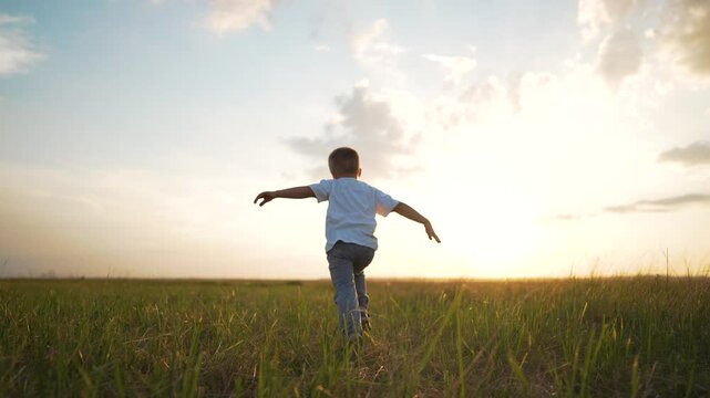 Happy child running. Imagination flying arms outstretched like pilot. play child dreams being pilot. Scenic outdoor adventure child playing freely. Future pilot fantasy child running imagining flight.