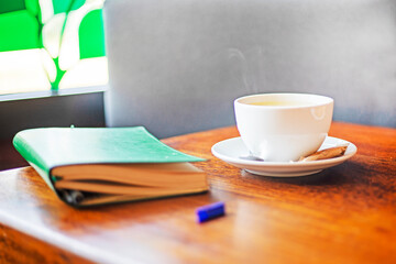 notebook with a cup of hot coffee or tea on the table. good morning. planning the day, week. Back to school