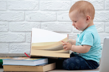 Little baby looks at a books. Intellectual development of newborns.