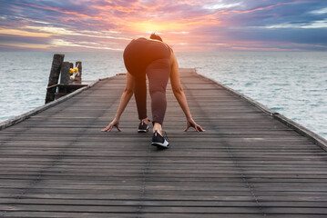 Young healthy woman practicing yoga on the bridge in the nature