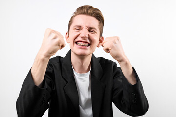 A man wearing a black jacket and white shirt is shown with his fists raised in a defensive posture....