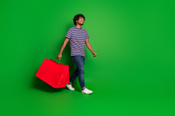 Photo of young mexican funny shopaholic man student wearing casual outfit walking with boutique...
