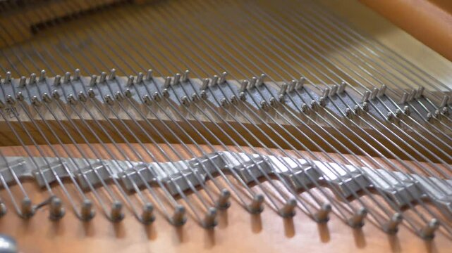 Aged grand piano's tight strings. Music instrument. Unique tonal qualities and role in classical and contemporary music. Tuning and repair of a musical instrument