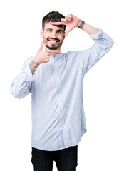 Fototapeta premium Young handsome business man over isolated background smiling making frame with hands and fingers with happy face. Creativity and photography concept.