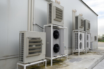 Air compressor or air condenser unit located on support outside building to heat released...