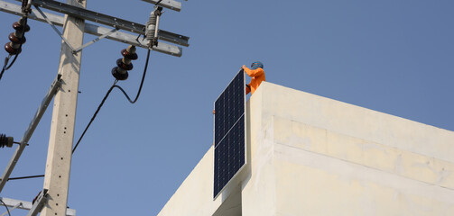 Obraz premium Worker installs solar panels. Worker installs solar panels at a solar farm field.