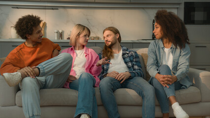 Multiethnic buddies multiracial people diversity friends Caucasian men guys male African women girls female at home sofa talking friendly conversation talk communication friendship relaxing together