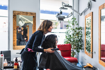 Hairdresser Styling Client's Hair with Hairdryer in Modern Salon