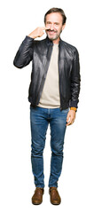 Middle age handsome man wearing black leather jacket Pointing with hand finger to face and nose, smiling cheerful