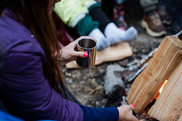 The woman peacefully sips her coffee by the fireplace in a cozy atmosphere created by the warmth of...
