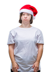 Young adult woman with down syndrome wearing christmas hat over isolated background with serious expression on face. Simple and natural looking at the camera.