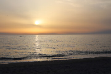 Obraz premium Sunset on the beach on a summer evening on the sea coast of Calabria, Italy