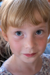 close-up portrait of a girl's face looking straight into the camera, blue-eyed blonde