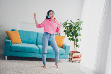 Photo of positive good mood woman dressed pink shirt headphones singing enjoying music modern gadget indoors house apartment room