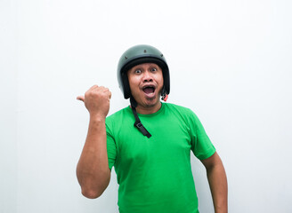 A man wearing motorcycle helmet smiling and pointing beside him