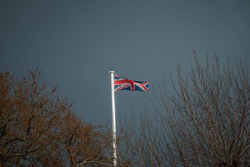 Englische Flagge weht im Wind mit einen dunklen Himmel 