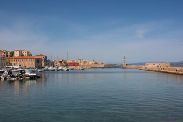 Fototapeta premium View over Rethymno harbour, blue water and blue sky, dam with Venetian lighthouse