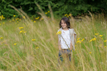 A little teenage girl wearing glasses, jeans, a T-shirt and a sweater thrown over her shoulders...