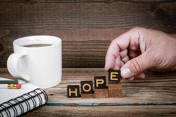 HOPE. Old letter tiles on wooden steps, development concept