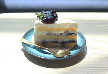 piece of blueberry cake on plate with spoon.