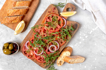 Organic tomato carpaccio with pesto sauce and arugula, an on-trend summer healthy eating salad 
