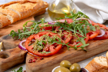 Organic tomato carpaccio with pesto sauce and arugula, an on-trend summer healthy eating salad 