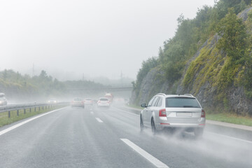 Back tail view of many cars driving fast on wet highway road after rain in Europe. Automobile...