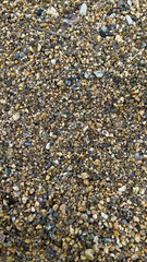 Texture of yellow sand with small pebbles. Sand pattern