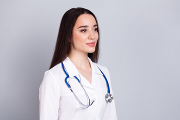 Photo of professional medical worker lady look empty space white coat isolated on grey color background