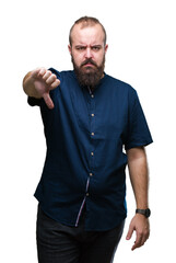 Young caucasian hipster man over isolated background looking unhappy and angry showing rejection and negative with thumbs down gesture. Bad expression.