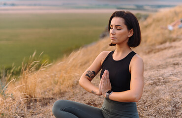 Woman doing yoga outdoors at sunset, symbolizing balance, harmony, tranquility in nature