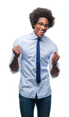 Afro american business man wearing glasses over isolated background very happy and excited doing winner gesture with arms raised, smiling and screaming for success. Celebration concept.